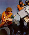 This photo was taken on board the USS Pennsylvania BB38 in 1941 and was a full page print in Our Navy magazine in the Nov. issue.  The magazine wanted an action shot showing our new style of helmets and life jackets.  The pose was staged at the 3" 50 caliber AA gun that I was Gun Captain on.  One of my best friends Seaman 1/c Dencil "Mac" Macintosh is the First Loader and I am wearing the headphones.  We weren't aware that Mac was wearing the helmet backwards.  Mac and his entire crew on Gun 9 (5" 25 AA) were killed by a 500 lb. bomb on Dec. 7th.  Submitted by Charles Serr (La Mesa, CA)
